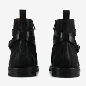 Black leather boots with buckle details on a white background