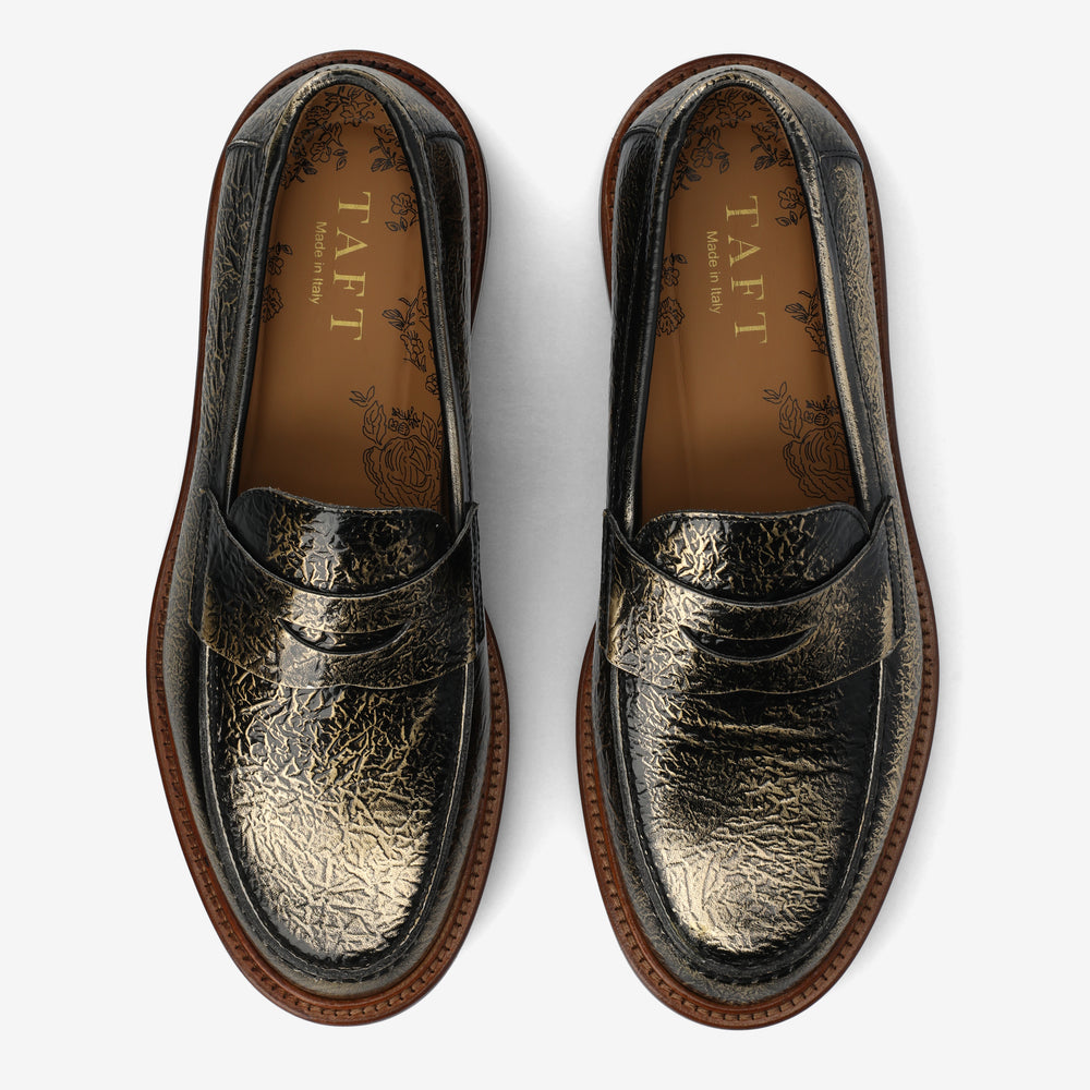 Pair of black leather loafers with gold embossed design with the label 'TAFT' on a white background