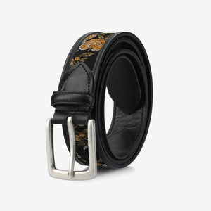 Black belt with floral pattern and silver buckle on a light gray background