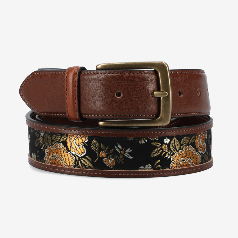 Brown leather belt with floral embroidery on a white background