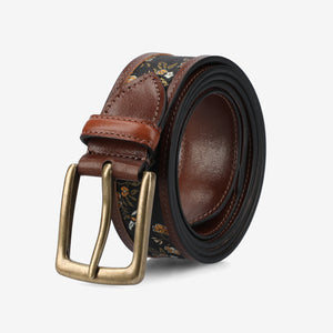 Brown leather belt with floral pattern and brass buckle on a light gray background