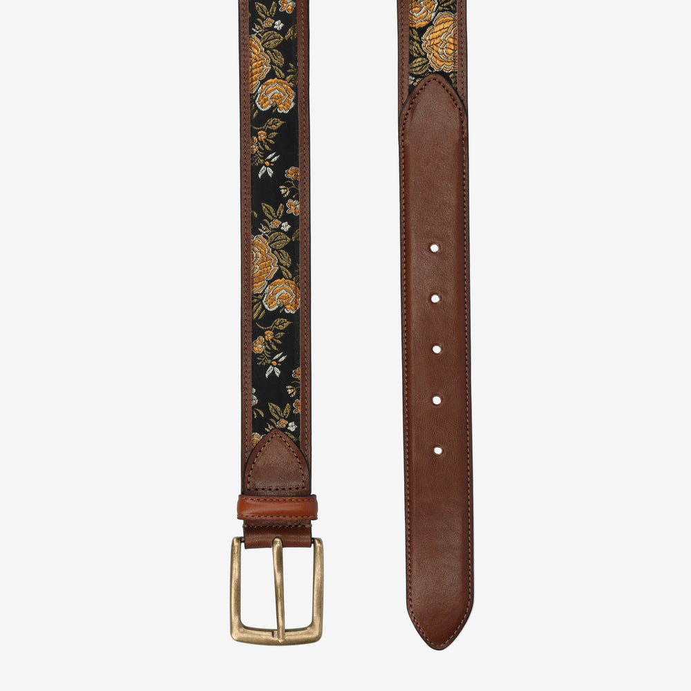 Brown leather belt with floral embroidery on a white background