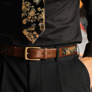 Person wearing a black shirt, brown floral belt with a matching floral tie. - lifestyle