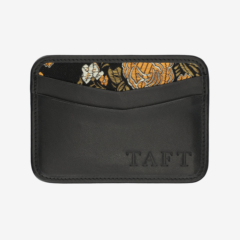 Black wallet with floral patterned flap and 'TAFT' branding on a white background
