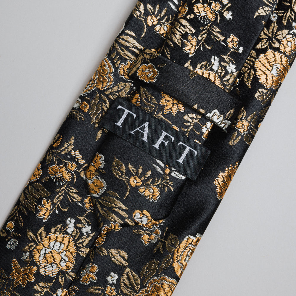 Floral-patterned tie with 'TAFT' label on a gray background